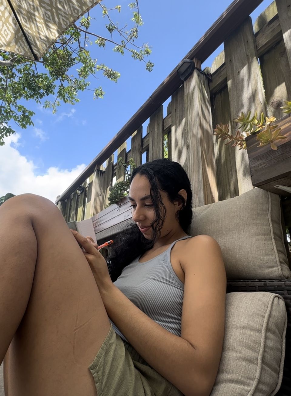 Ariana journaling on a lounge chair outdoors